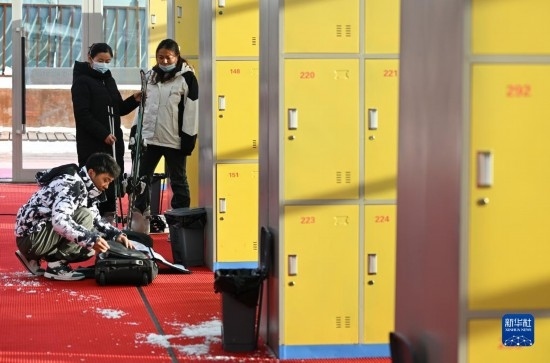 12月21日，游客在滑雪服務(wù)大廳整理滑雪裝備。