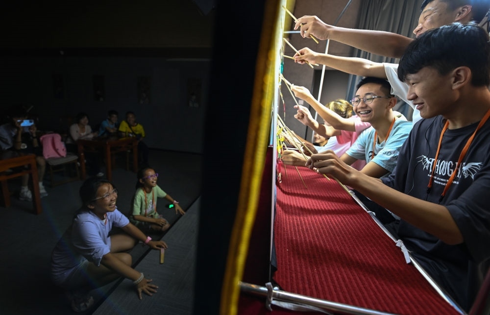 2023年8月8日，進行暑期研學(xué)的學(xué)生在位于陜西省西安市的中國秦腔藝術(shù)博物館體驗皮影戲演出。新華社記者 鄒競一 攝