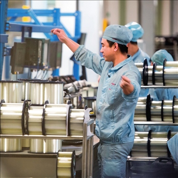 在位于武漢的長飛光纖光纜股份有限公司光纖生產(chǎn)車間內(nèi)，工作人員對光纖進(jìn)行檢測（資料圖片）。肖藝九攝/本刊