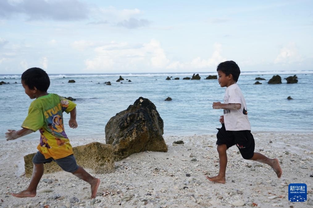 1月20日，兒童在瑙魯海邊嬉戲。新華社記者 王申 攝