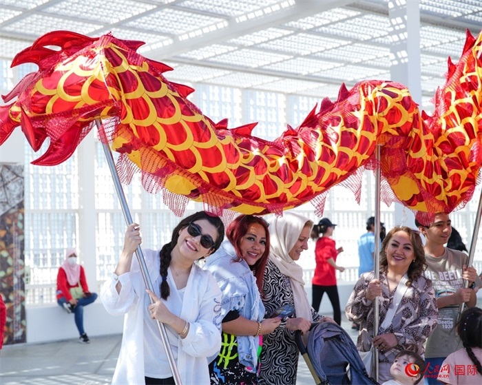 游客體驗(yàn)舞龍。 人民網(wǎng) 塔里克·易卜拉欣攝