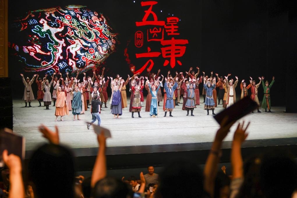 2023年7月31日，新疆和田地區(qū)新玉歌舞團(tuán)在烏魯木齊京劇院演出舞劇《五星出東方》后和觀(guān)眾互相揮手致意。這場(chǎng)演出是第六屆中國(guó)新疆國(guó)際民族舞蹈節(jié)的參演劇目之一，曾榮獲國(guó)家“文華獎(jiǎng)”等。新華社記者 郝昭 攝