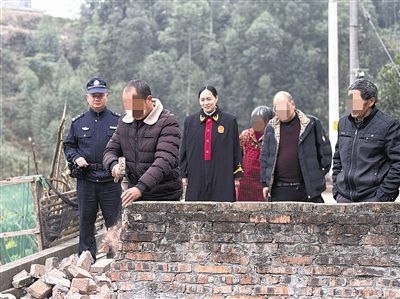  圖③：庭審結(jié)束后，在法官的見證下，陳某在院壩邊重新開鑿一條通道。