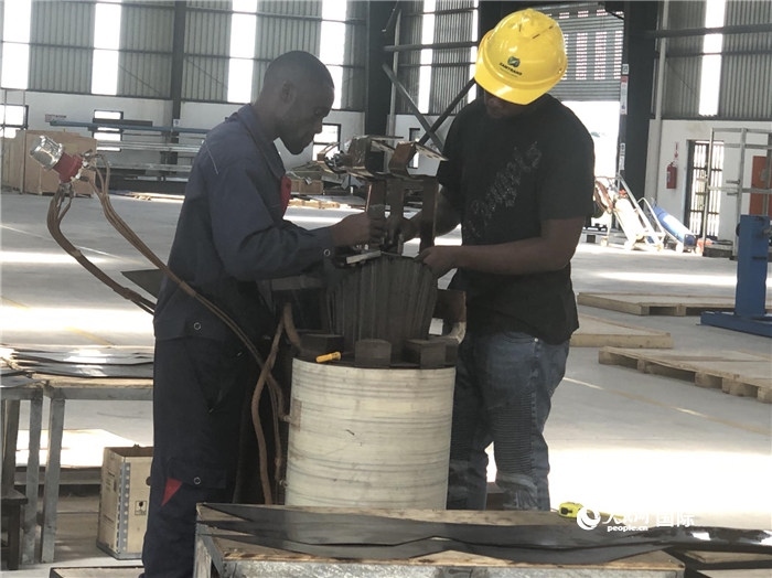 經(jīng)貿(mào)合作區(qū)廠房?jī)?nèi)，當(dāng)?shù)毓と苏诰o張作業(yè)。人民網(wǎng)記者 黃培昭攝