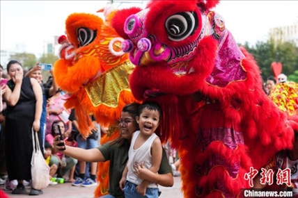 圖為舞獅表演吸引民眾合影。張興龍攝