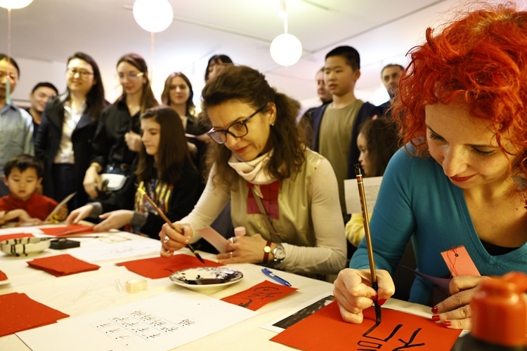 羅馬尼亞觀眾學(xué)習(xí)用毛筆寫“?！弊?。中國(guó)文化中心供圖