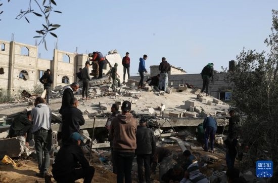  3月3日，在加沙地帶南部城市拉法，人們查看被以軍空襲破壞的建筑。新華社發(fā)（哈立德·奧馬爾攝）