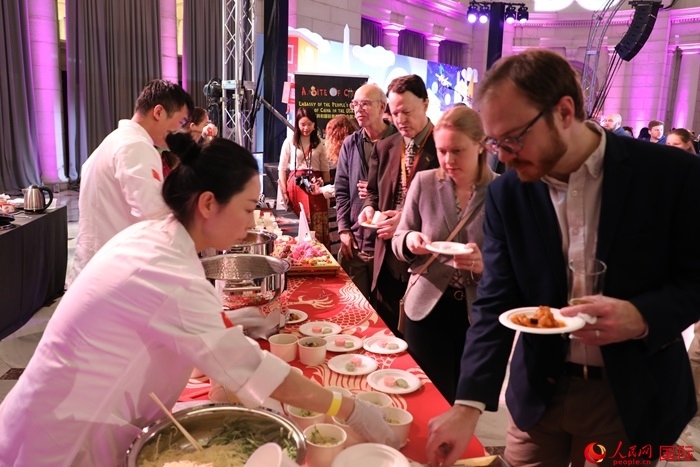 當(dāng)?shù)貢r間3月7日晚，華盛頓聯(lián)合車站廣場舉行駐美使團(tuán)“使館主廚挑戰(zhàn)賽”。圖為當(dāng)?shù)孛癖娫谥袊古_前體驗中國美食。人民網(wǎng)記者 李志偉攝