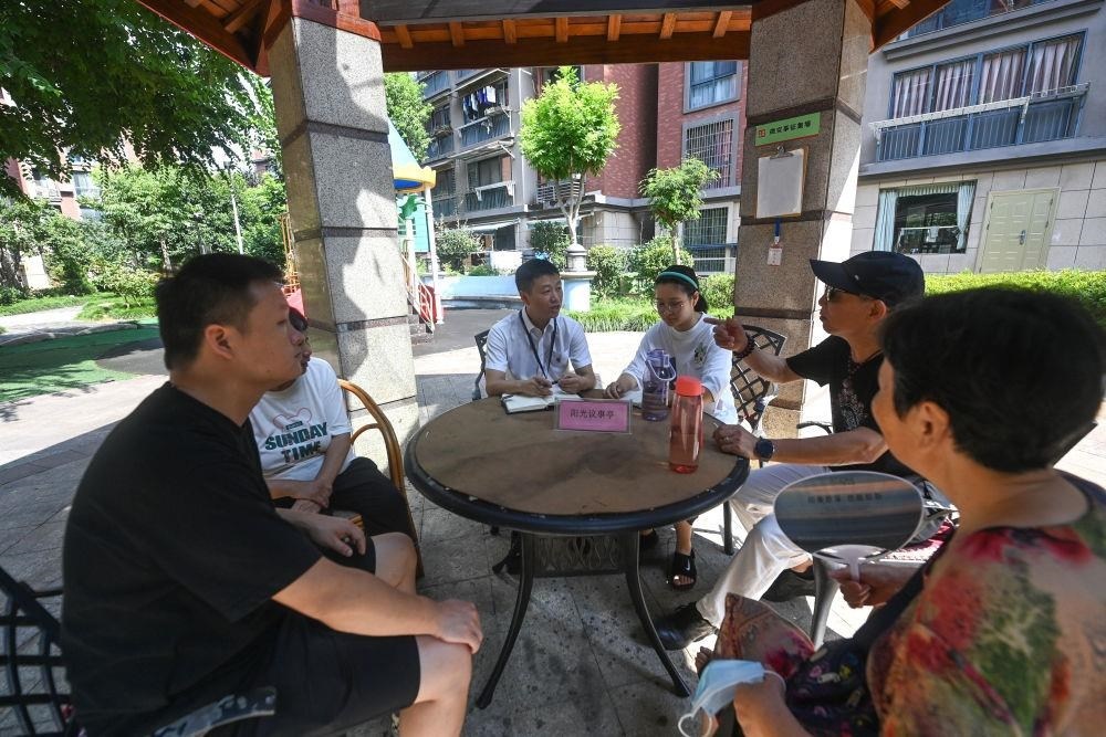 △2023年7月21日，在位于浙江杭州臨安區(qū)錦南街道水岸陽光小區(qū)的陽光議事廳，街道干部在聽取居民們反映的問題及意見。