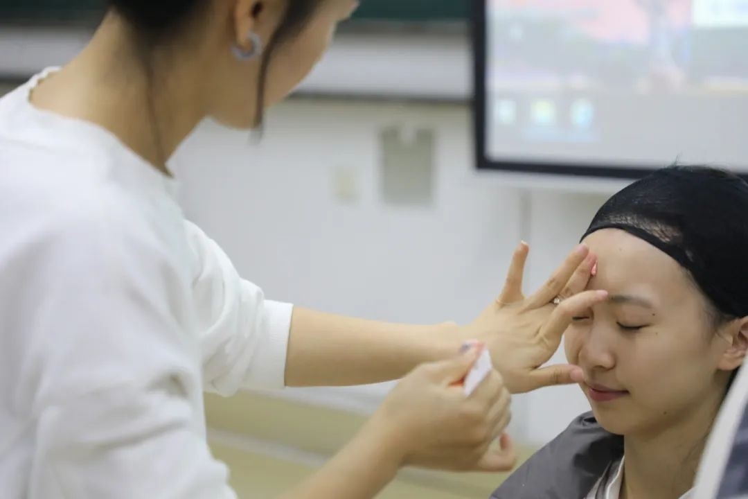 課堂上，一名學(xué)生在體驗(yàn)上戲妝。學(xué)校供圖