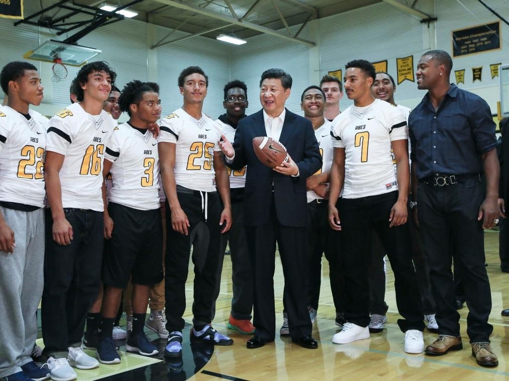 2015年9月23日，國(guó)家主席習(xí)近平參觀美國(guó)塔科馬市林肯中學(xué)。這是習(xí)近平在學(xué)校體育館，同上橄欖球訓(xùn)練課的學(xué)生們親切交談。新華社記者 蘭紅光 攝