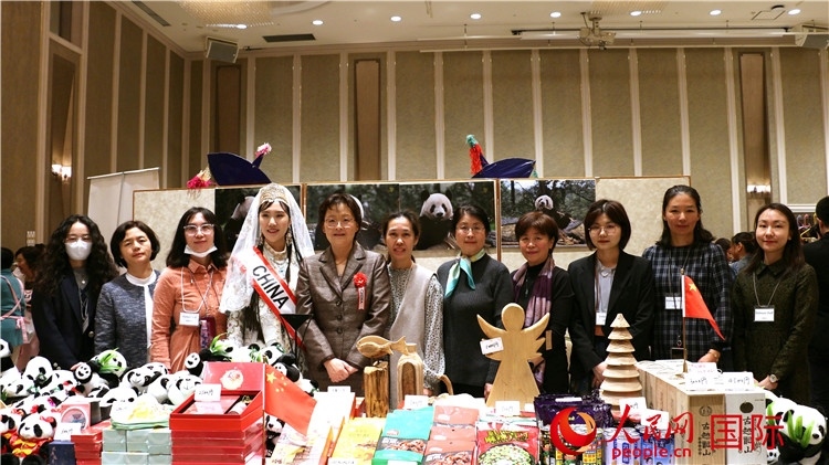 中國駐日本大使吳江浩夫人丁玥（左五）與使館人員在展位前合影留念。人民網(wǎng) 許可攝