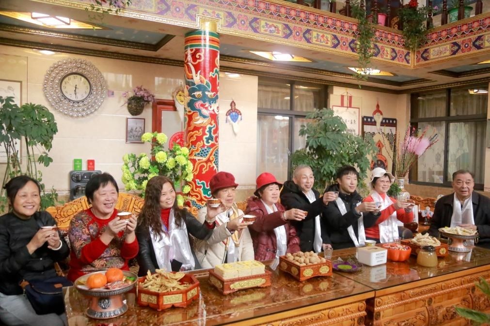 游客們?nèi)胱∶袼藓螅e杯共飲酥油茶。新華社記者 邱星翔 攝