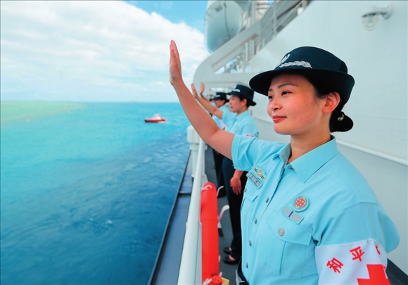 中國海軍“和平方舟”號醫(yī)院船結束訪問湯加時，任務官兵中的文職人員向歡送人群揮手告別（2023年8月4日攝）。徐巍攝/本刊