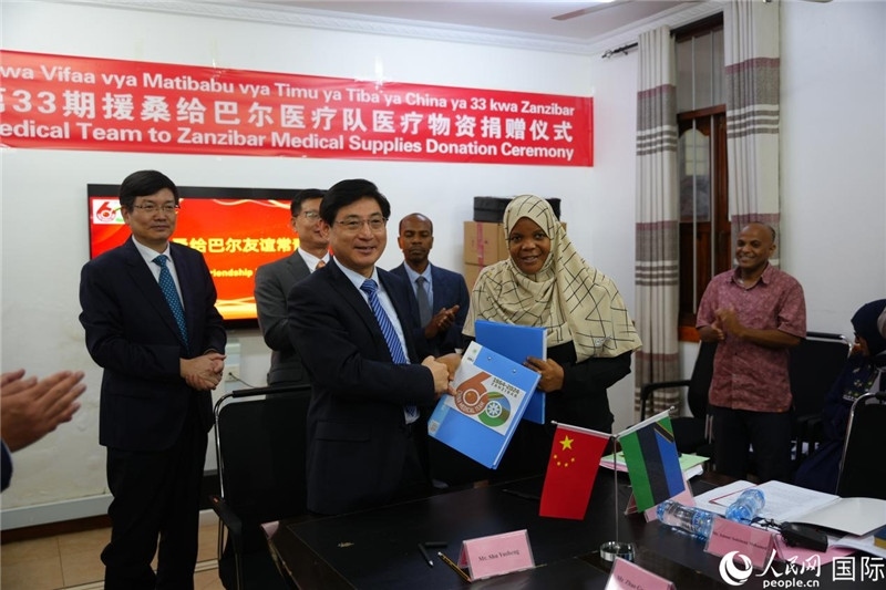 江蘇省蘇北人民醫(yī)院黨委書記束余聲與桑衛(wèi)生部首席秘書哈比巴交換捐贈(zèng)書。中國援桑醫(yī)療隊(duì)供圖