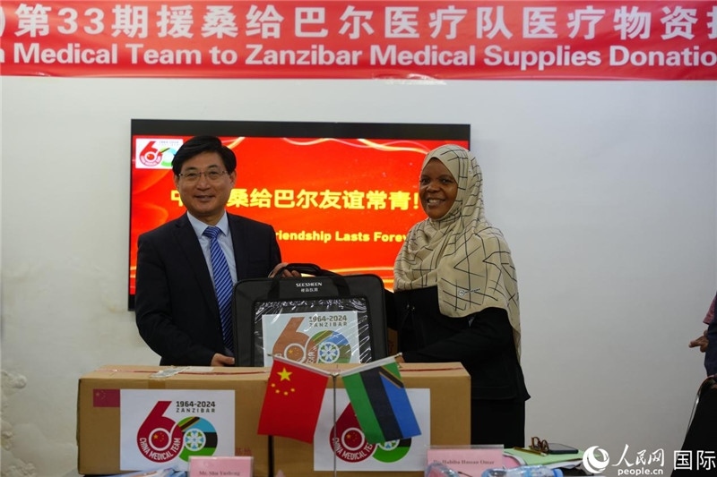 江蘇省蘇北人民醫(yī)院黨委書記束余聲捐贈(zèng)物資與桑衛(wèi)生部首席秘書哈比巴。中國援桑醫(yī)療隊(duì)供圖