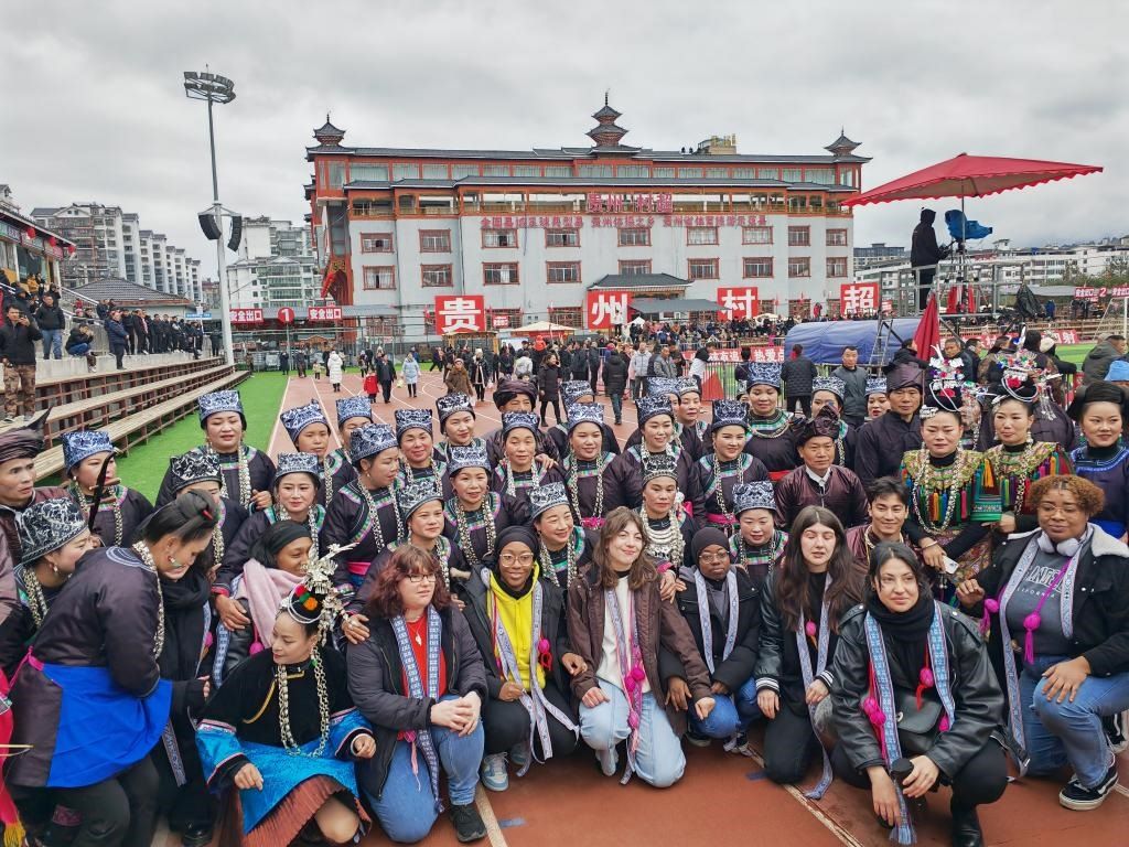 法國青年在“村超”賽場邊與參加表演的村民合影。新華社記者 羅羽 攝