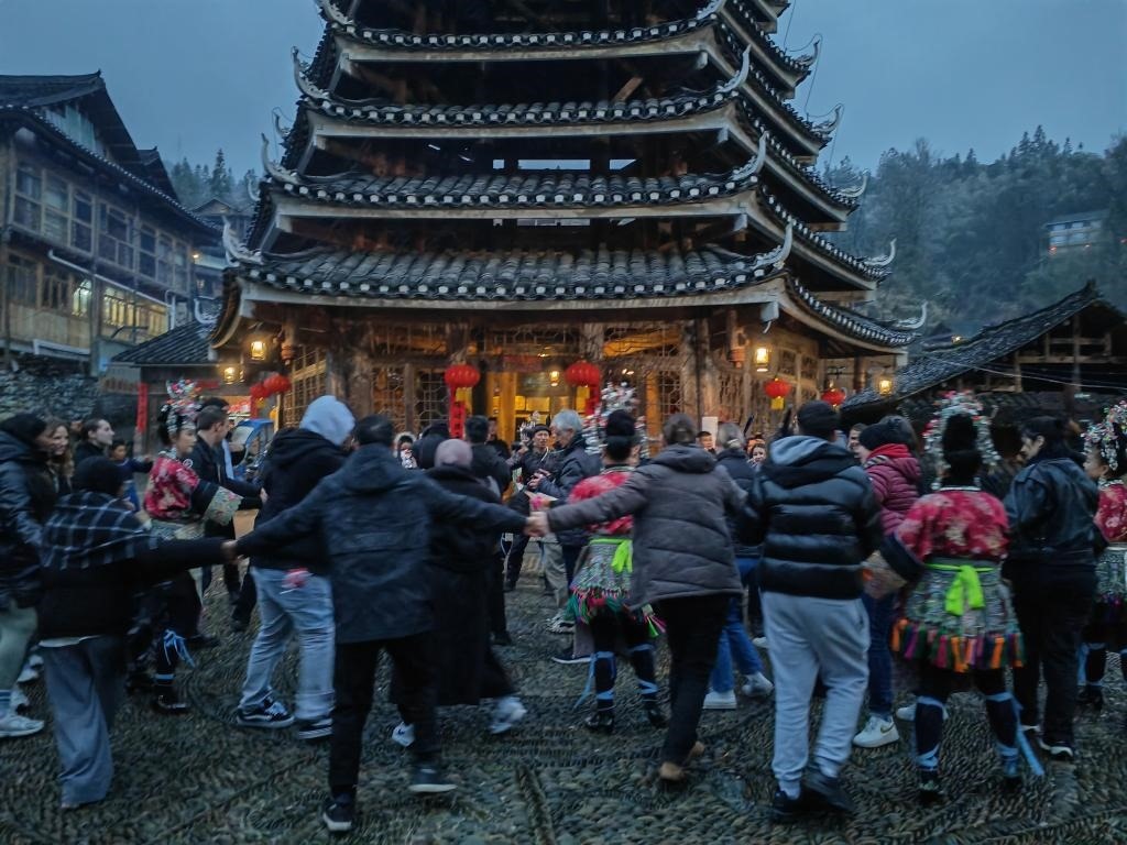 法國青年與當(dāng)?shù)卮迕駹渴痔?。新華社記者 羅羽 攝