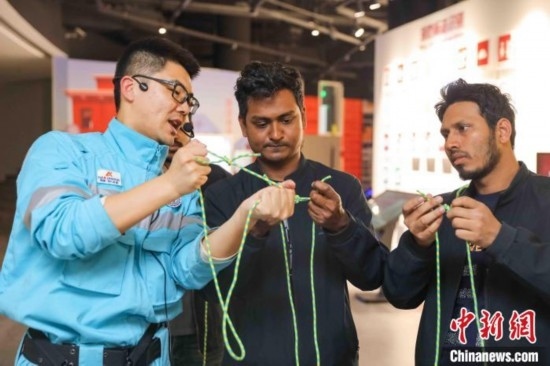 5月9日，工作人員指導(dǎo)留學(xué)生學(xué)習(xí)打繩結(jié)。張鷹 攝