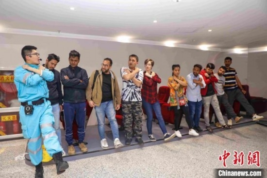 5月9日，工作人員指導(dǎo)留學(xué)生練習(xí)逃生技巧。張鷹 攝