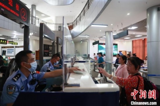 圖為旅客在磨憨口岸辦理通關(guān)手續(xù)。雷雨 攝