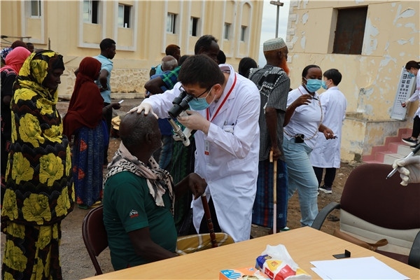 在義診現(xiàn)場(chǎng)，中國(guó)醫(yī)生與當(dāng)?shù)鼐用窈嫌傲裟?，吉布提鹽業(yè)投資公司供圖