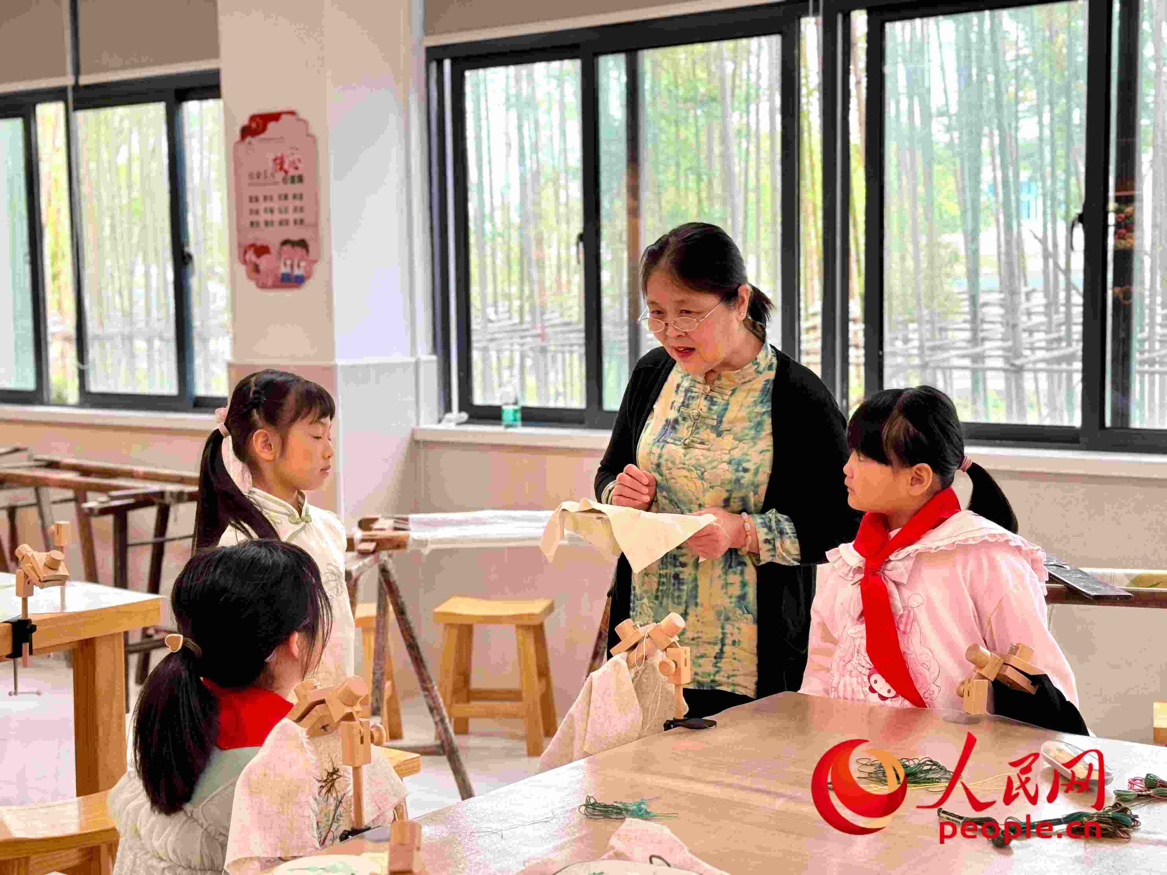 顧建珍（左三）在教孩子們刺繡知識。人民網 周靜圓攝