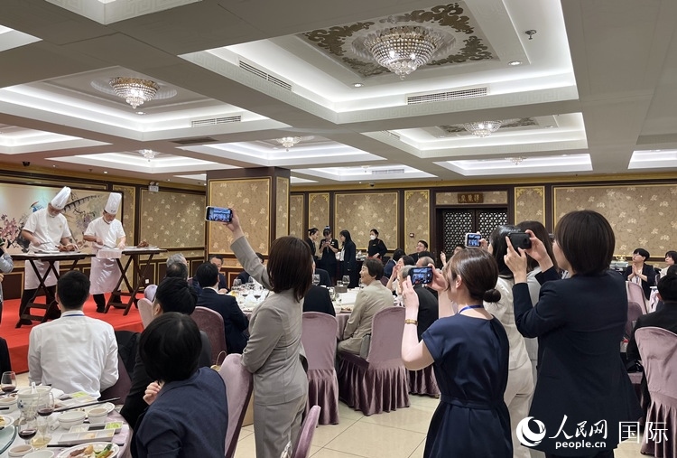 國(guó)家級(jí)非物質(zhì)文化遺產(chǎn)、全聚德片鴨工藝吸引代表團(tuán)成員拍照留念。