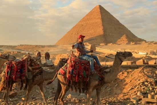 1月24日，商販騎駱駝離開埃及吉薩金字塔景區(qū)。新華社記者 隋先凱 攝