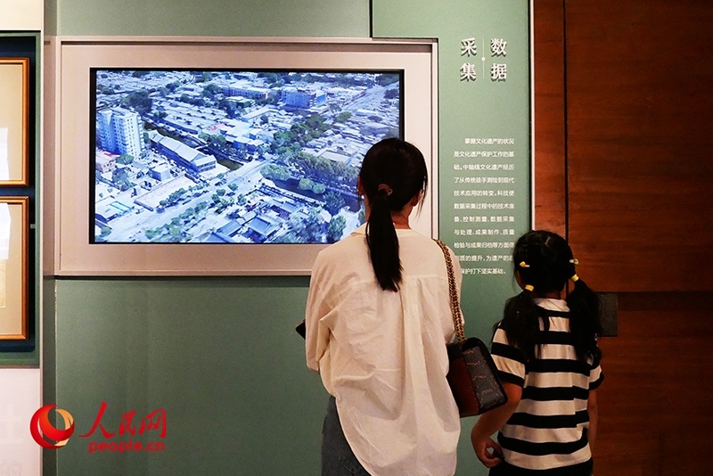 家長正在帶孩子參觀“輝煌中軸”專題展。人民網(wǎng)記者 韋衍行攝