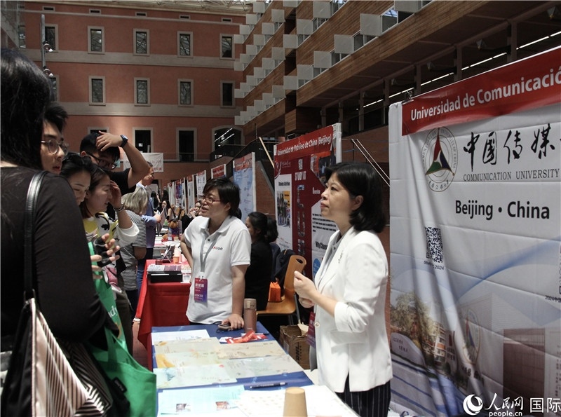 旅西華人華僑在展臺前咨詢。人民網(wǎng)記者 許海林攝