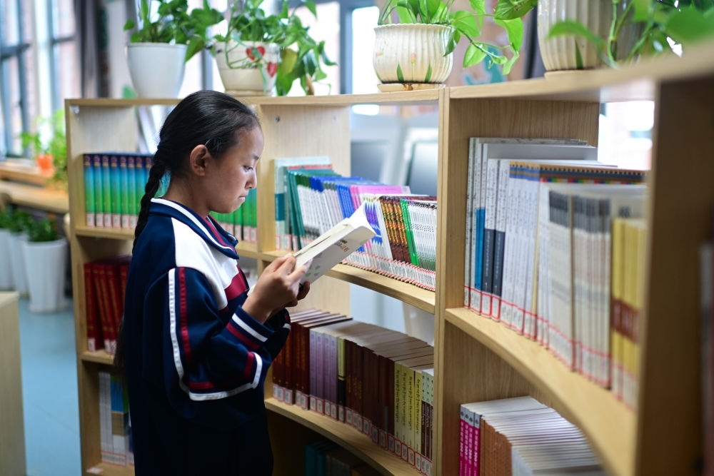 6月18日，果洛西寧民族中學(xué)學(xué)生尼東拉毛在圖書室看書。