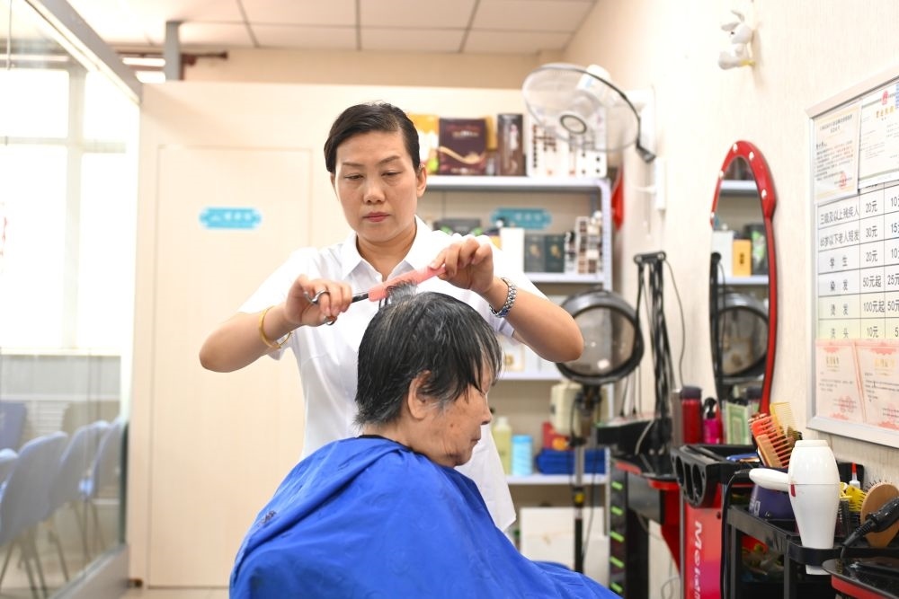 6月20日，長城花園社區(qū)的志愿者為居民理發(fā)。