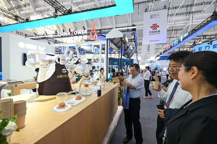 6月20日，與會者品嘗機器人沖調(diào)出的咖啡。新華社記者 孫凡越 攝