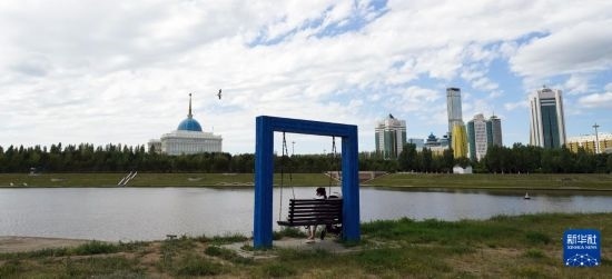6月30日，一名女子在哈薩克斯坦首都阿斯塔納伊希姆河畔休息。新華社記者 王建華 攝