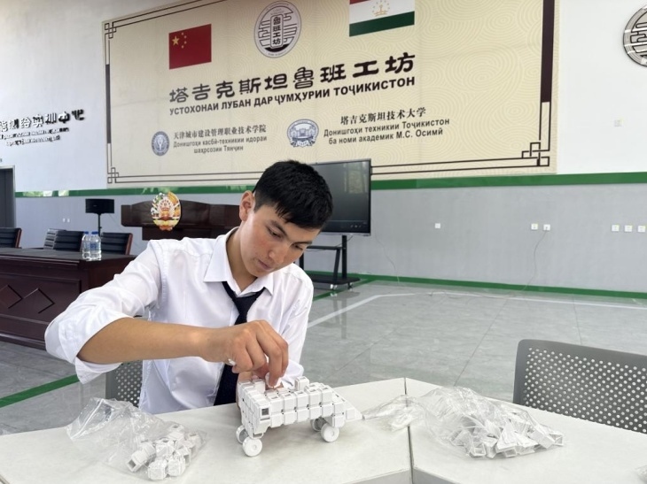 在塔吉克斯坦魯班工坊內(nèi)，學員正在操作能力源創(chuàng)新套件。本報記者 屈佩 攝