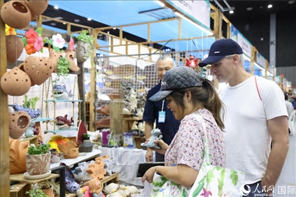 游客在蘭納博覽會(huì)特色展位上選購(gòu)工藝品。人民網(wǎng)記者楊一攝