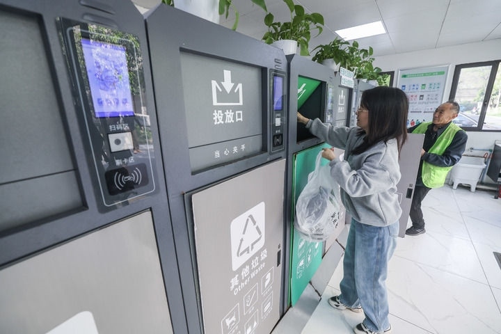 2024年4月10日，在浙江省湖州市吳興區(qū)飛英街道新華府小區(qū)內(nèi)，居民在垃圾分類智能系統(tǒng)的指導下進行垃圾分類投放，居民的投放情況將實時匯總到智慧服務平臺，會有相應的積分獎勵。新華社記者 徐昱 攝