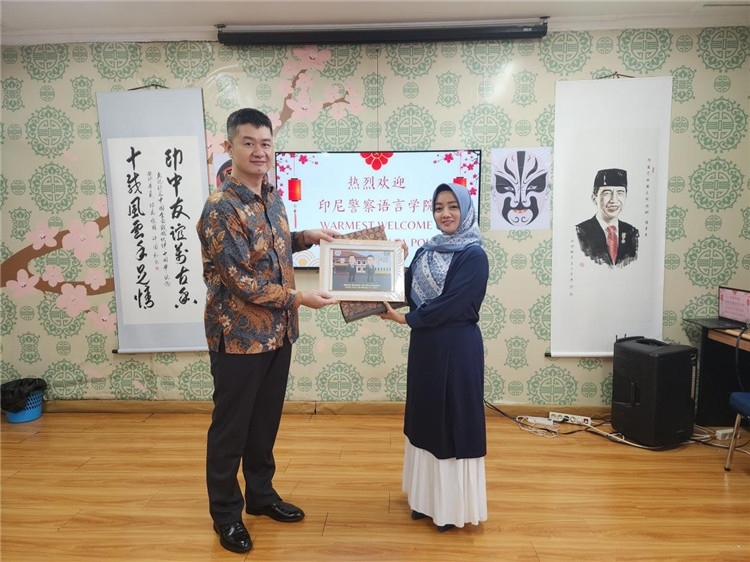 警察語言學(xué)院老師與王大昕交換禮品?；顒又鬓k方供圖