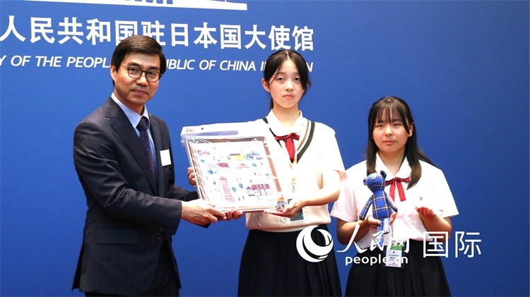 日本小大使向中國駐日本大使館臨時代辦施泳贈送當地特色禮品。人民網 許可攝