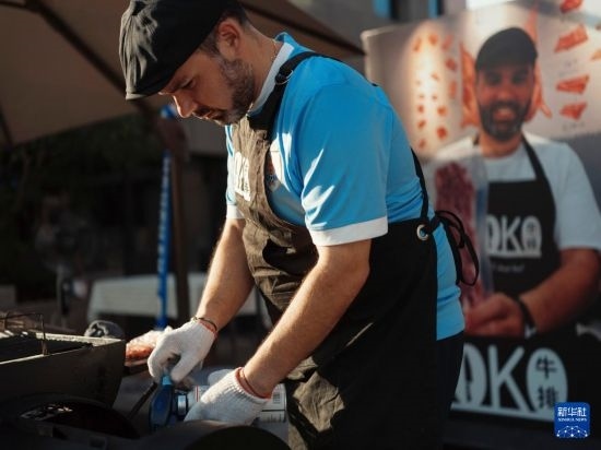 7月19日，在蕪湖古城，馬丁在當(dāng)天舉行的啤酒節(jié)上制作牛排。新華社發(fā)（繆雨晨 攝）
