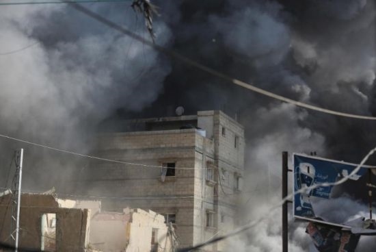 7月21日，在加沙地帶中部的努賽賴特難民營，遭以軍空襲的建筑冒出滾滾濃煙。新華社發(fā)（馬爾萬·達(dá)烏德攝）