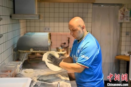 近日，韋榮耀在自家披薩小店內(nèi)忙活。俞靖 攝