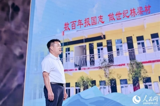 張玉滾分享用一根扁擔(dān)送孩子們走出大山的故事。人民網(wǎng)攝