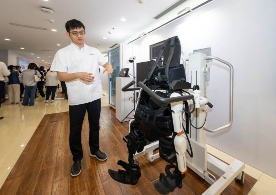 2024年5月24日，在位于上海市嘉定區(qū)的上海交通大學醫(yī)學院附屬瑞金醫(yī)院腫瘤質子中心，工作人員介紹由瑞金醫(yī)院醫(yī)生和醫(yī)療公司共同研發(fā)的用于恢復患者下肢的醫(yī)療機器人。新華社記者 王翔 攝