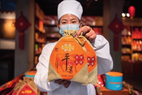 在位于山西省晉中市平遙縣的平遙古城南大街的一家平遙牛肉店內(nèi)，工作人員展示一款牛肉產(chǎn)品（資料照片）楊晨光攝 / 本刊