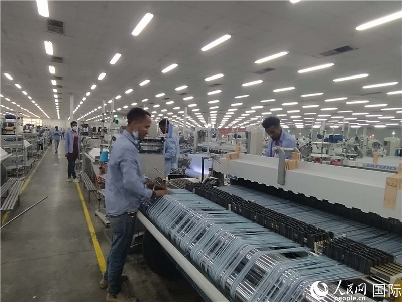 無錫金茂埃塞面料廠車間內(nèi)，當?shù)毓と苏谝唤z不茍地作業(yè)。人民網(wǎng)記者 黃培昭攝