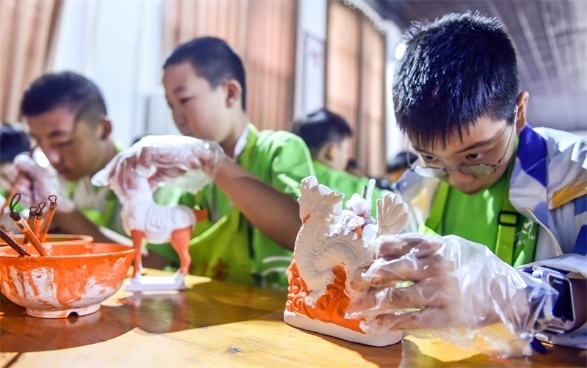 小朋友們?cè)诼尻?yáng)市孟津區(qū)朝陽(yáng)鎮(zhèn)南石山村體驗(yàn)唐三彩素胎施釉技藝。圖片來(lái)源：視覺(jué)中國(guó)