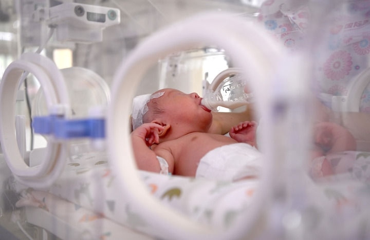 2024年6月1日，在西安國(guó)際醫(yī)學(xué)中心醫(yī)院新生兒科病房，護(hù)士為新生兒喂奶。 新華社記者 劉瀟 攝