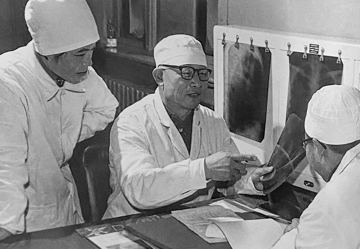 1980年1月16日，中日友好醫(yī)院首任院長(zhǎng)辛育齡（中）在內(nèi)蒙古結(jié)核病院與胸外科醫(yī)師討論病例（翻拍照片）。 新華社發(fā)